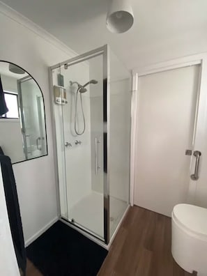 Chuveiro, toalhas de banho, sabonete, shampoo