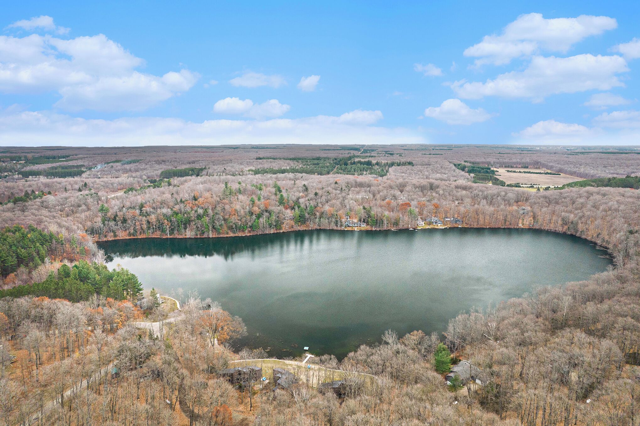 A lake surrounded by trees and a clear sky.