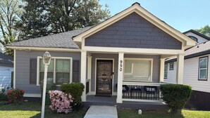 A residential house with a front porch, a mailbox, and a number '950' on the door.