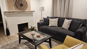 A living room with a fireplace, a sofa, a coffee table, and a yellow armchair.