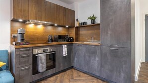 Una cocina moderna con armarios de madera, horno empotrado y cafetera.