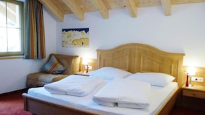 A neatly made bed with white linens, a wooden headboard, and bedside lamps. - Holiday Home, Fiss (Fiss)