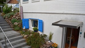 A house with a stone staircase leading to a door with a glass panel.