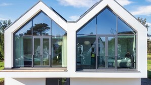 A modern building with large glass windows and a white exterior. - Ferienhaus in Fuhlendorf (Fuhlendorf)