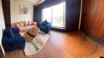 A modern living room with a sofa, two armchairs, and a coffee table.