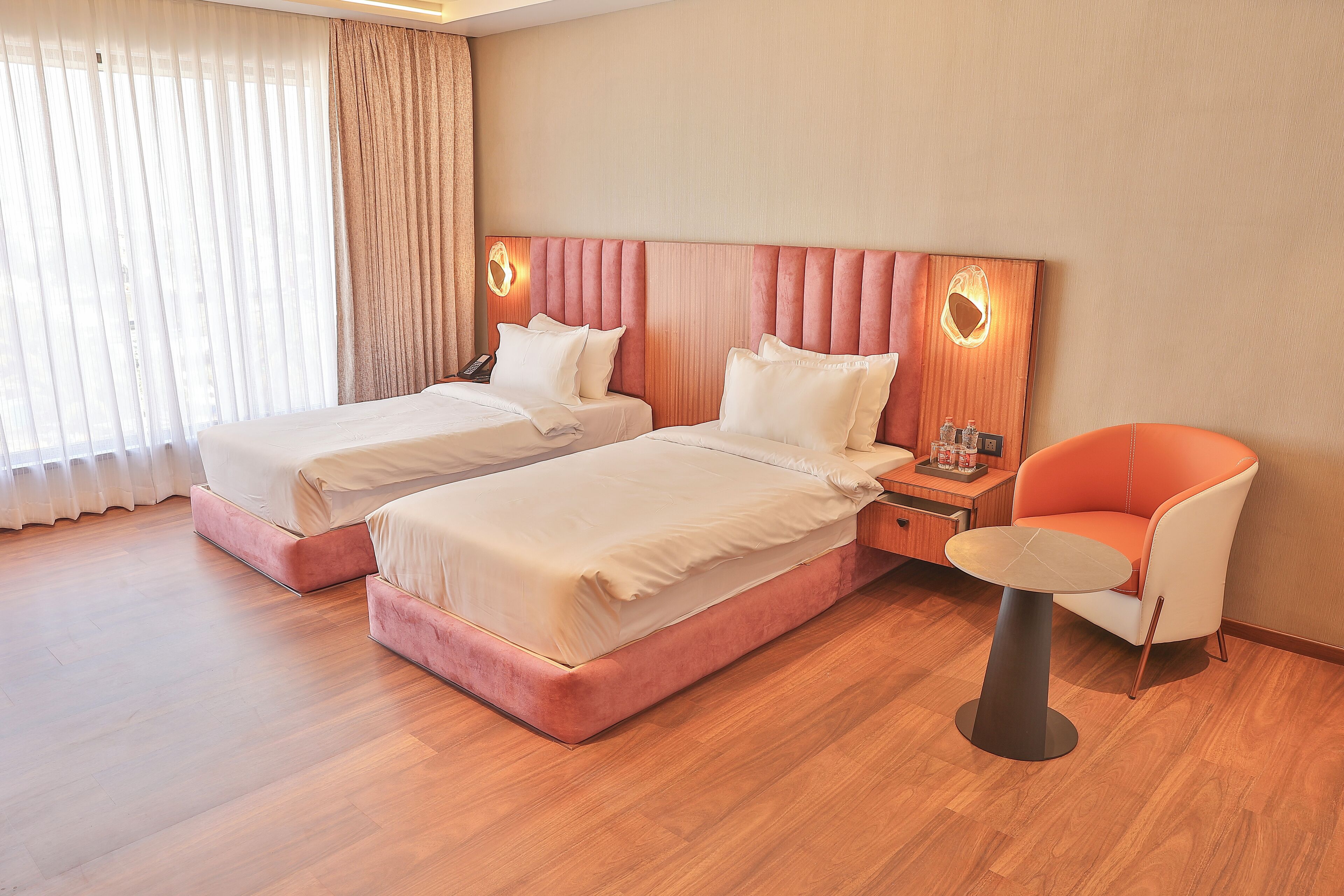 Une chambre d’hôtel avec deux lits, une petite table et une chaise.