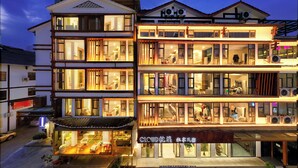 Ein mehrstöckiges Hotel mit traditioneller Architektur, mit Balkonen und großen Fenstern.