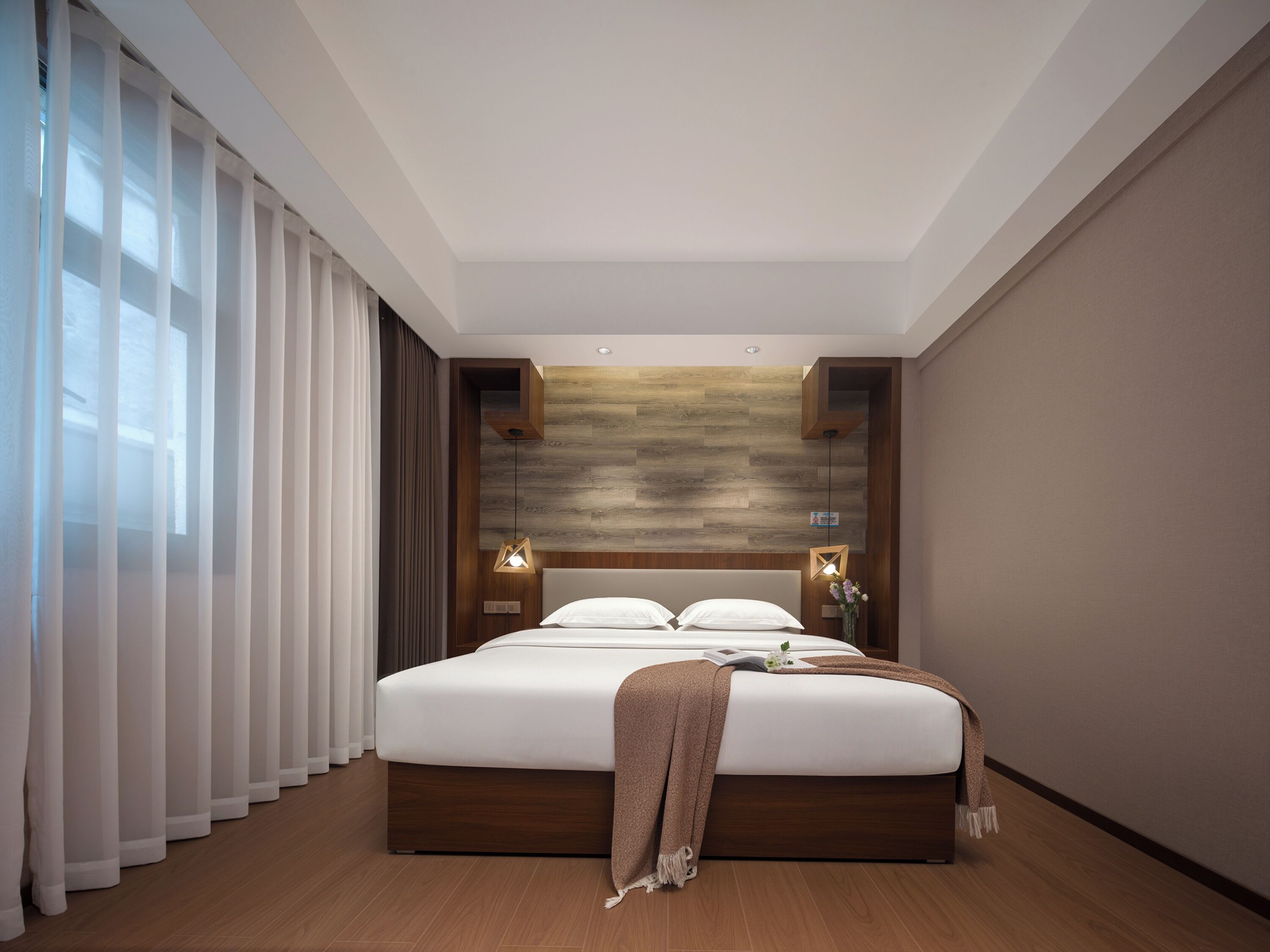 A modern bedroom with a large bed, wooden headboard, and a wooden wall panel.