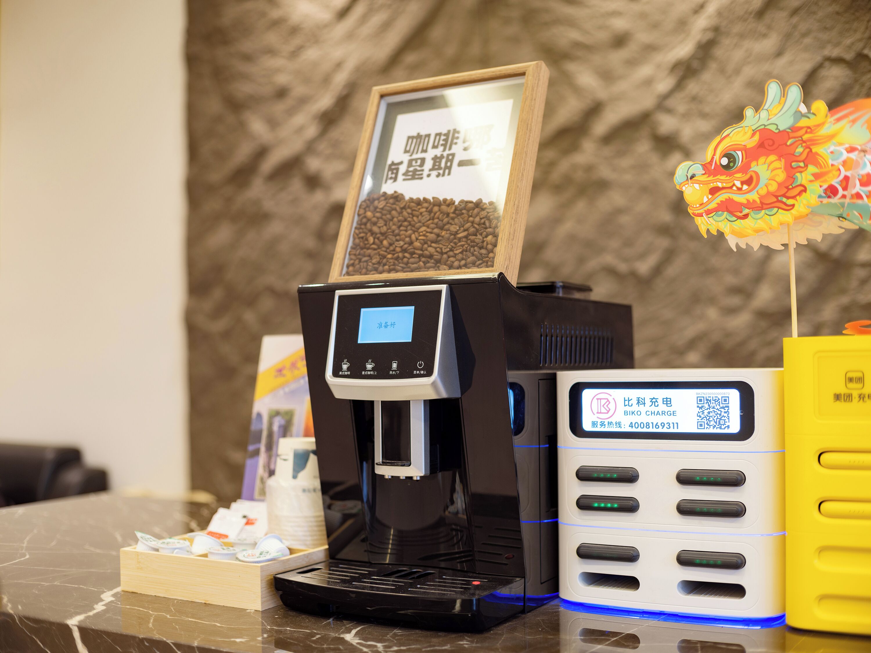Une machine à café dotée d’un écran numérique, d’un code QR et d’une station de recharge.