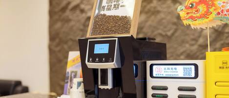 Une machine à café dotée d’un écran numérique, d’un code QR et d’une station de recharge.