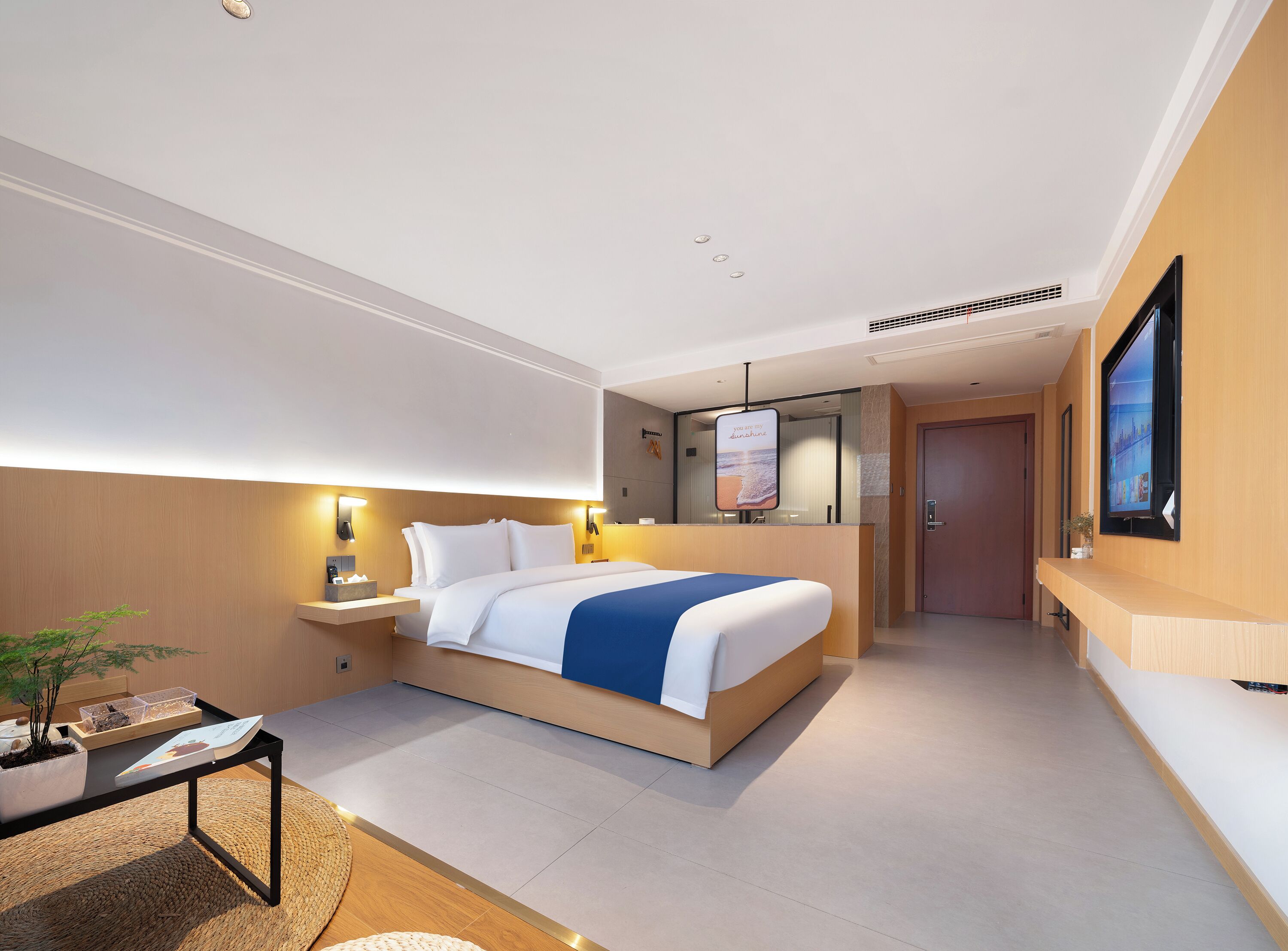 Een moderne hotelkamer met een groot bed, nachtkastjes, een bureau en een televisie.