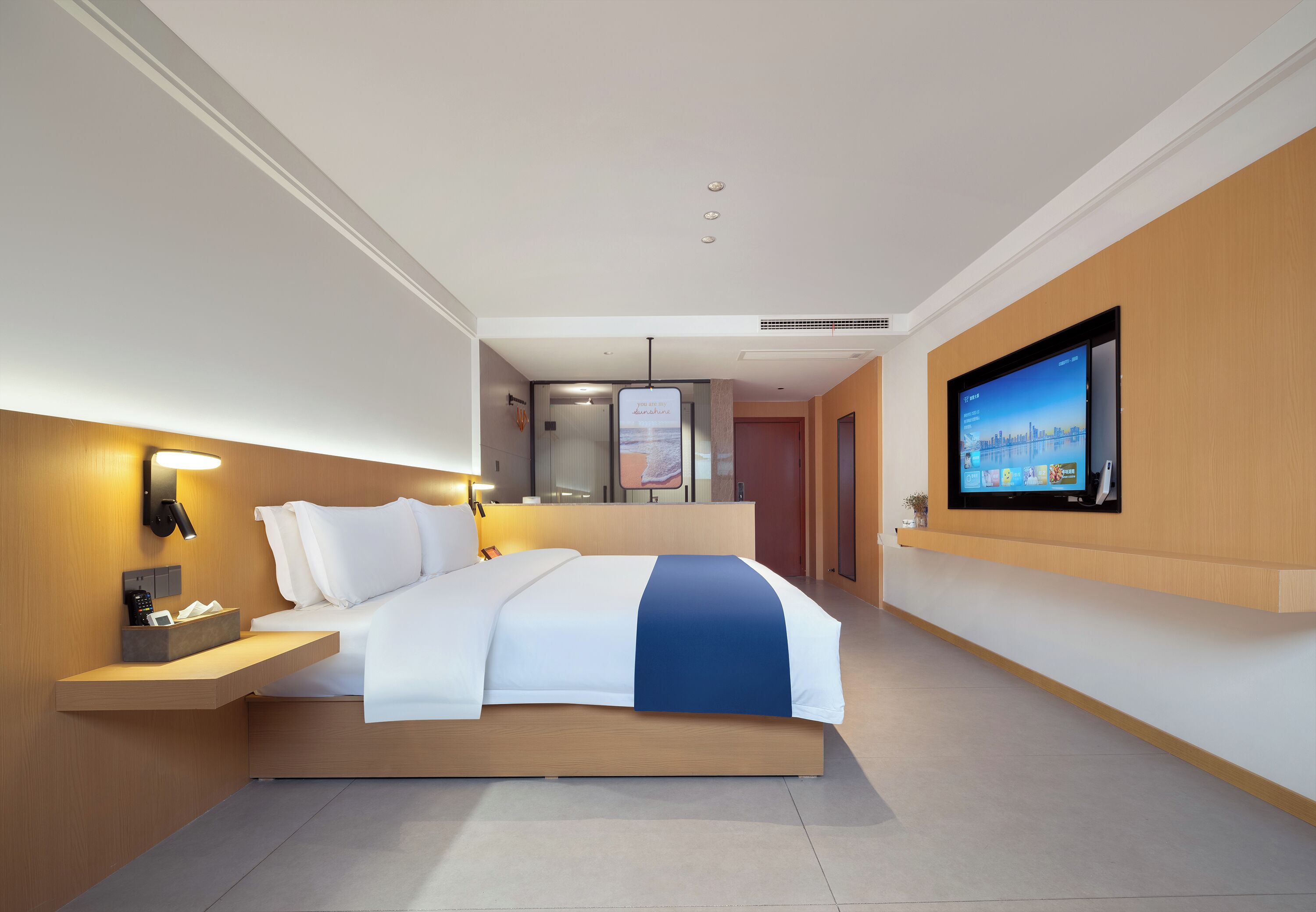 Een moderne hotelkamer met een bed, nachtkastje, televisie en uitzicht op de stad.