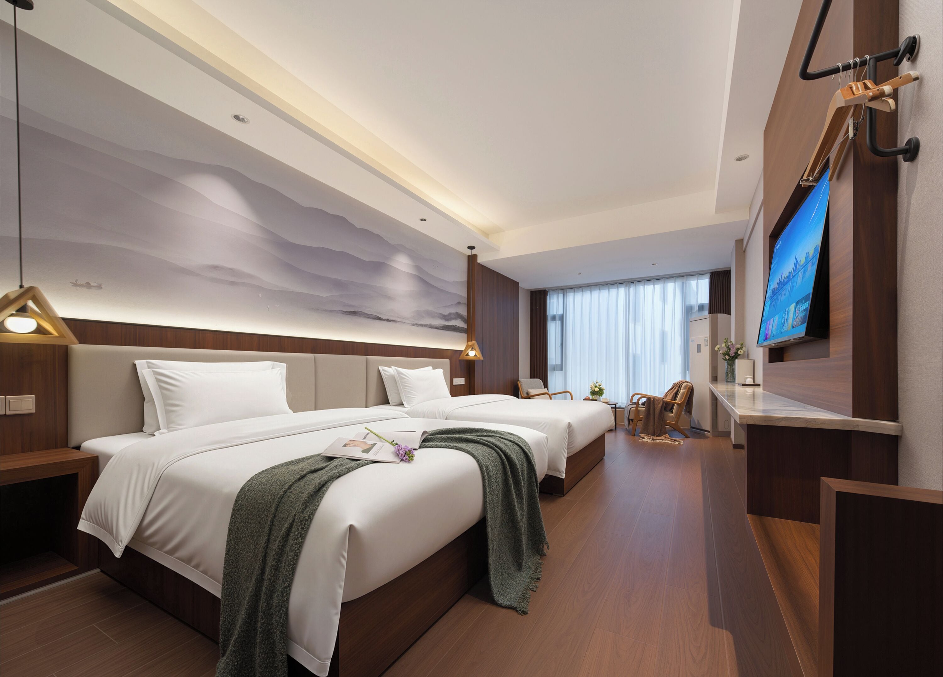 A hotel room with two beds, a TV, a desk, and a large wall mural.