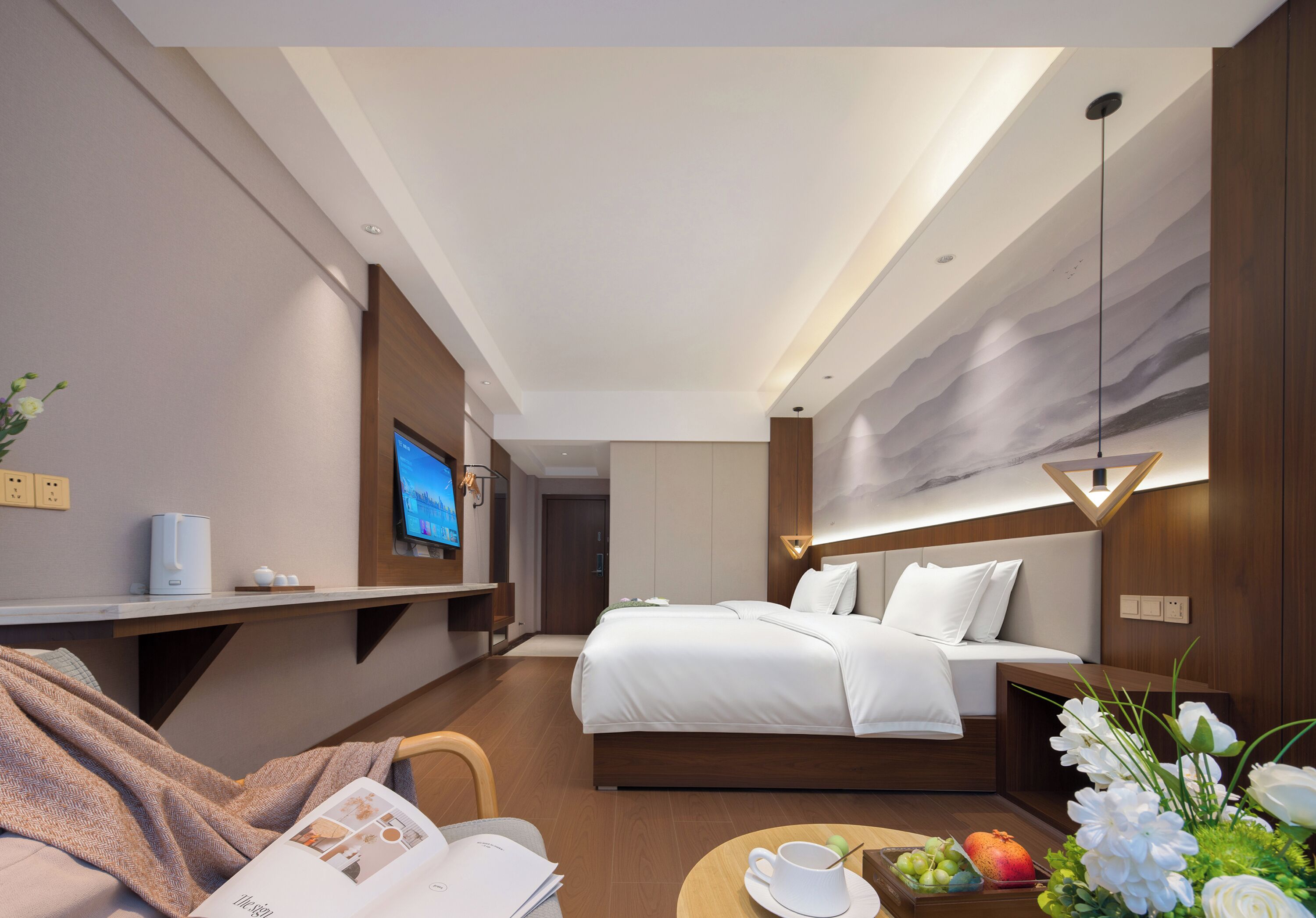 Quarto de hotel moderno com cama, mesa de cabeceira, televisão e área de refeições com mesa posta para dois.