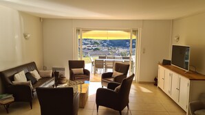 A living room with a sofa, chairs, a coffee table, and a TV on a cabinet. - In a postcard setting! Villa 10 people Drome Provençale  (Buis-les-Baronnies)