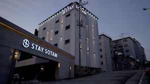 A hotel named Stay SOTAM with a modern facade and illuminated signage. - Songdo Stay Sotam (Incheon)