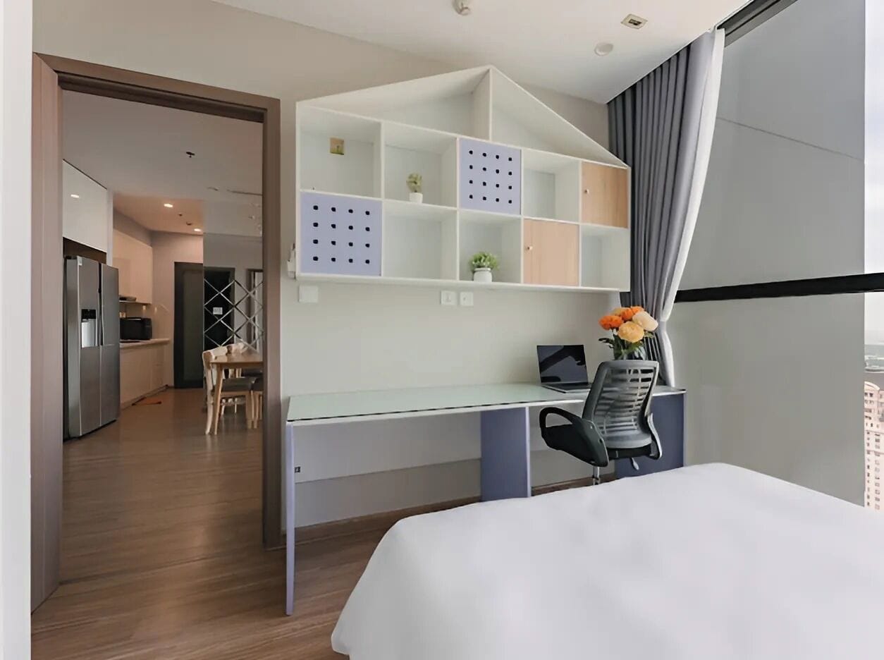 Une chambre d’hôtel moderne, équipée d’un bureau, d’une chaise, d’un lit et offrant une vue sur la ville.