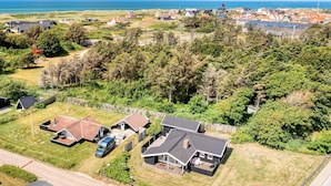 Zona residencial com casas, um parquinho e vista para o mar.