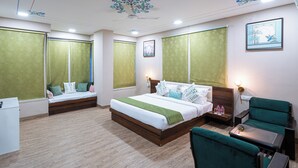 Una habitación de hotel con cama, escritorio, silla y una pequeña mesa.