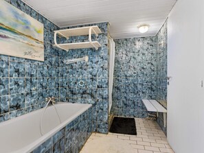 A bathroom with a bathtub, a shower, and a sink. - 5 Star Holiday Home in Lokken (Lokken)