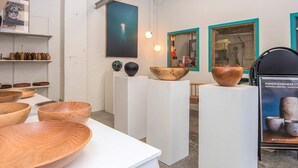 A modern interior with white walls, wooden bowls on display, and a poster advertising pottery. - 2 Person Holiday Home in Ringkobing (Ringkobing)