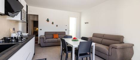 Un espacio moderno para vivir con cocina, comedor y sofá.