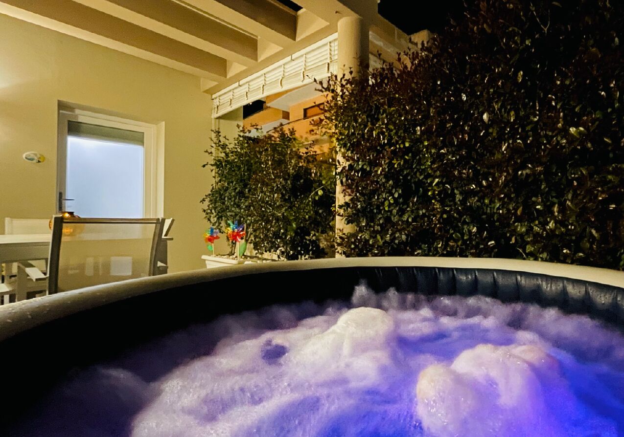 Ein Whirlpool mit Blick auf einen Balkon und Zimmerpflanzen.