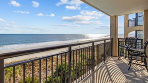 Uma varanda com vista para a praia e o oceano.