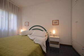 Een hotelkamer met een bed, nachtkastjes en een kledingkast.