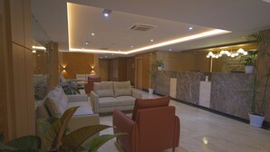 A modern lobby with a sofa, armchairs, and potted plants. - Siddhartha Hotel Damauli (Byas)