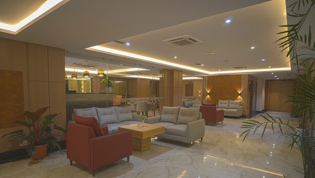 A spacious lobby with modern furniture, a marble floor, and ambient lighting. - Siddhartha Hotel Damauli (Byas)