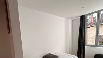 Une chambre à coucher avec un lit, une fenêtre et une vue sur l’extérieur.