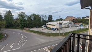 En vy över en väg som leder fram till en byggnad med ett område täckt av grus och parkerade bilar.