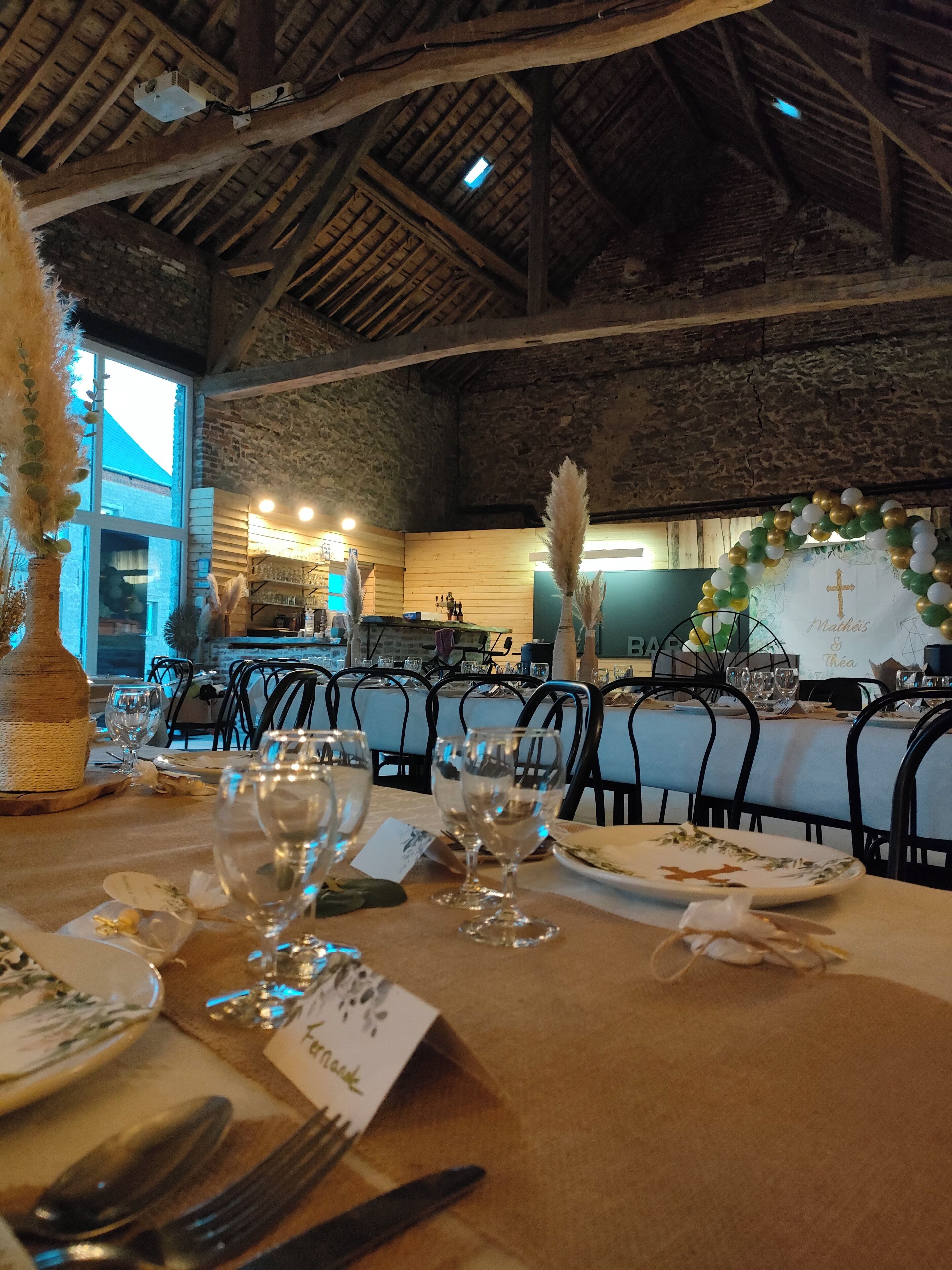 Een restaurant met rustieke houten balken en bakstenen muren, met een gedekte tafel voor een maaltijd, inclusief wijnglazen en borden.