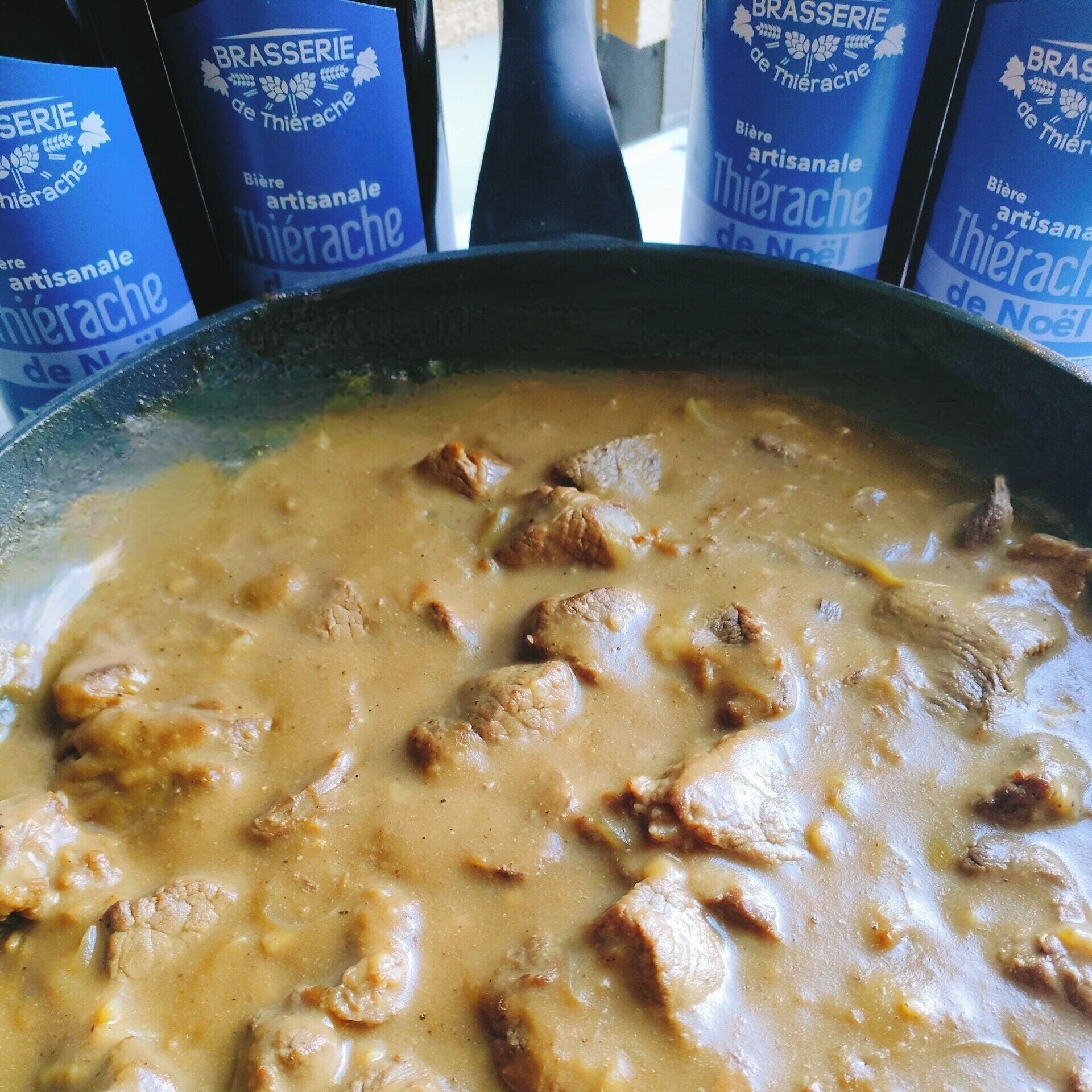 Un plat contenant une sauce crémeuse et des morceaux de viande, probablement un ragoût ou un curry.