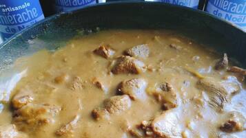Un plat contenant une sauce crémeuse et des morceaux de viande, probablement un ragoût ou un curry.