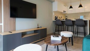 A modern living room with a flat-screen TV, a wooden coffee table, and a sofa. - w *| Grand 1BR with Great Balcony in San Isidro (San Isidro)