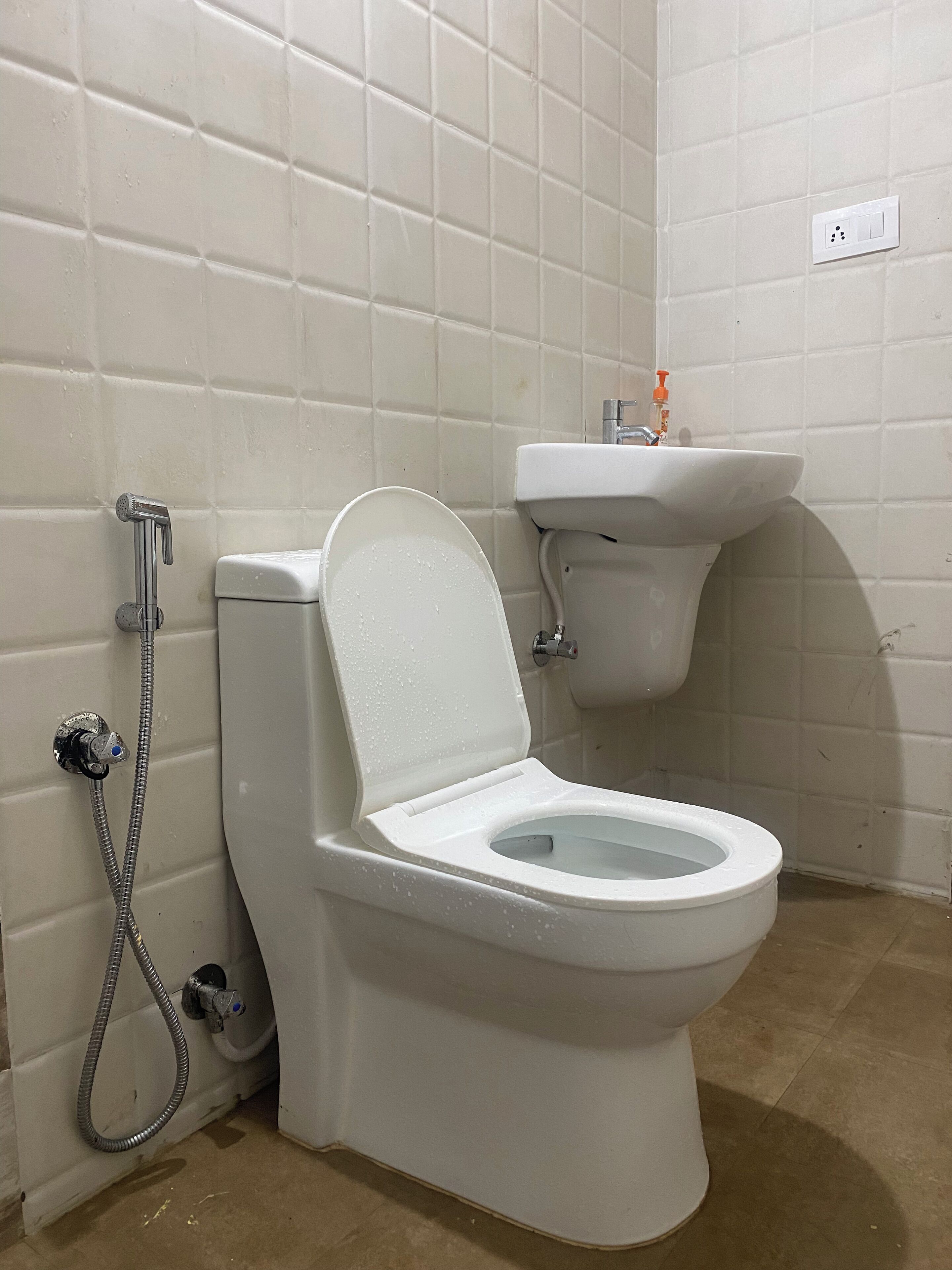 A bathroom with a toilet, a sink, and a shower.