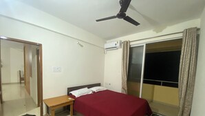 A bedroom with a bed, bedside table, and a ceiling fan. - Spacious 2BHK Mountain View | Near Palolem Beach (Canacona)