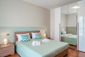 Un dormitorio moderno con una cama grande, dos mesitas de noche y un espejo.