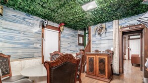A dining area with a marble wall, wooden furniture, and a green leafy ceiling. - ★★ Gondor ★★. OSU Dragon Castle Barcade (Columbus)