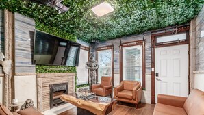 A living room with a fireplace, leather sofas, a coffee table, and a television. - ★★ Gondor ★★. OSU Dragon Castle Barcade (Columbus)
