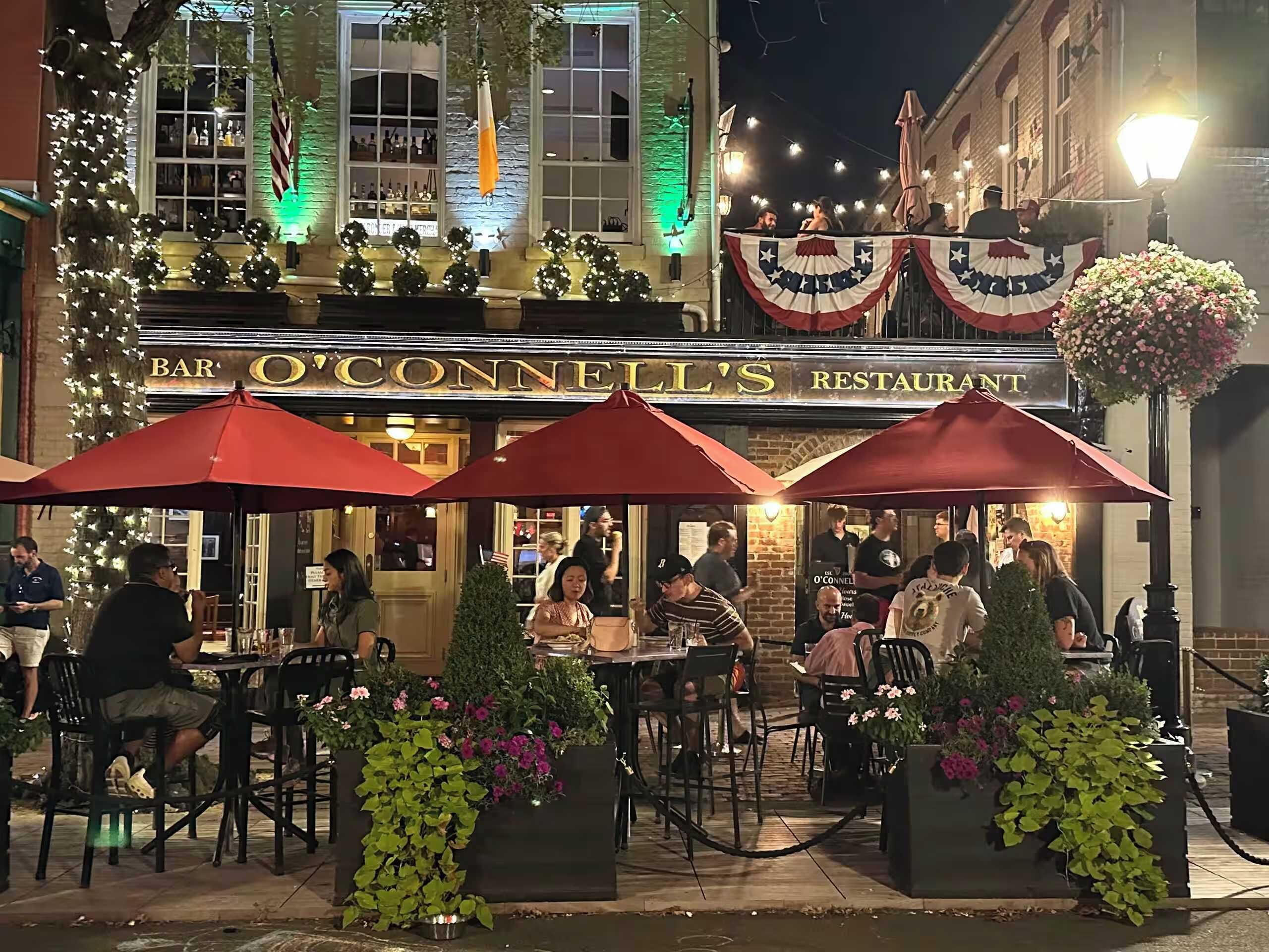 En restaurang med uteservering, bord och stolar, och en skylt med texten ”BAR O’CONNELL’S RESTAURANT”.