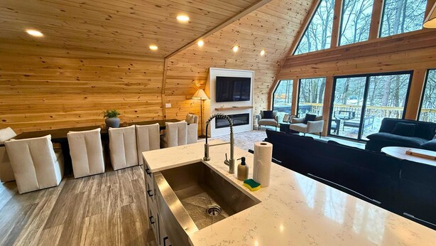 Ein modernes Blockhaus-Interieur mit Küche, Essbereich und Wohnzimmer.