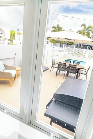 A balcony with a pool, outdoor furniture, and umbrellas. - AQUA Casa A/8 Rm 3 · Bedroom in Dorado del Mar (Dorado)