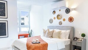 A modern bedroom with a bed, bedside table, and wall decor.