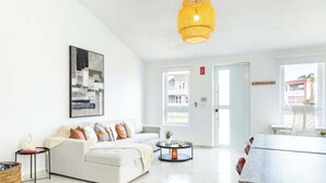 A modern living room with a sofa, coffee table, and artwork on the wall. - AQUA Casa A8 · Private & FUN 3 BR House with Pool (Dorado)