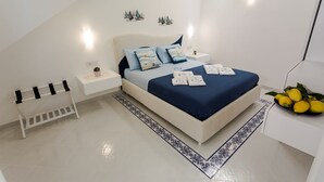 Un dormitorio moderno con una cama, mesitas de noche, una pequeña estantería y un elemento decorativo en la pared.