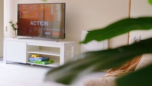 A television on a white stand with a Scrabble box underneath. - City Center Stay, With Parking (Hobart)
