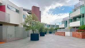 A modern building with a flat roof, large windows, and a paved courtyard. - City Center Stay, With Parking (Hobart)